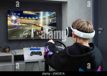 Osnabrück, Deutschland 29. Avril 2024 Im Bild : Ein Jugendlicher sitzt mit einer Virtual Reality brille, VR brille, vor einem Fernseher und spielt, zockt, ein Konsolenspiel auf einer Konsole. B ZEHN Niedersachsen *** Osnabrück, Allemagne 29 avril 2024 dans l'image Un jeune est assis devant une télévision avec des lunettes de réalité virtuelle, des lunettes VR, et joue, joue, un jeu de console sur une console B ZEHN Niedersachsen Copyright : xFotostandx/xGelhotx Banque D'Images