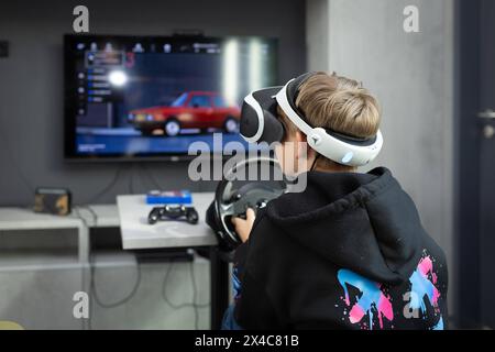 Osnabrück, Deutschland 29. Avril 2024 Im Bild : Ein Jugendlicher sitzt mit einer Virtual Reality brille, VR brille, vor einem Fernseher und spielt, zockt, ein Konsolenspiel auf einer Konsole. B ZEHN Niedersachsen *** Osnabrück, Allemagne 29 avril 2024 dans l'image Un jeune est assis devant une télévision avec des lunettes de réalité virtuelle, des lunettes VR, et joue, joue, un jeu de console sur une console B ZEHN Niedersachsen Copyright : xFotostandx/xGelhotx Banque D'Images