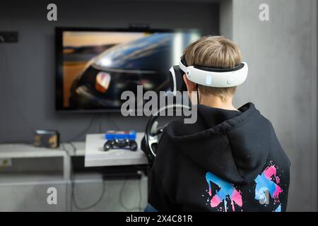 Osnabrück, Deutschland 29. Avril 2024 Im Bild : Ein Jugendlicher sitzt mit einer Virtual Reality brille, VR brille, vor einem Fernseher und spielt, zockt, ein Konsolenspiel auf einer Konsole. B ZEHN Niedersachsen *** Osnabrück, Allemagne 29 avril 2024 dans l'image Un jeune est assis devant une télévision avec des lunettes de réalité virtuelle, des lunettes VR, et joue, joue, un jeu de console sur une console B ZEHN Niedersachsen Copyright : xFotostandx/xGelhotx Banque D'Images