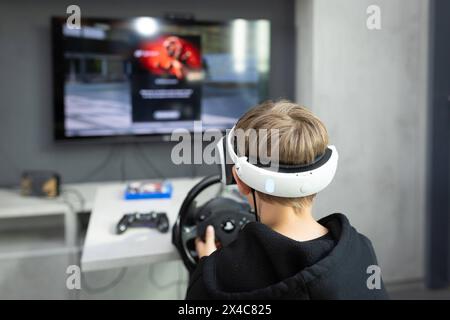 Osnabrück, Deutschland 29. Avril 2024 Im Bild : Ein Jugendlicher sitzt mit einer Virtual Reality brille, VR brille, vor einem Fernseher und spielt, zockt, ein Konsolenspiel auf einer Konsole. B ZEHN Niedersachsen *** Osnabrück, Allemagne 29 avril 2024 dans l'image Un jeune est assis devant une télévision avec des lunettes de réalité virtuelle, des lunettes VR, et joue, joue, un jeu de console sur une console B ZEHN Niedersachsen Copyright : xFotostandx/xGelhotx Banque D'Images