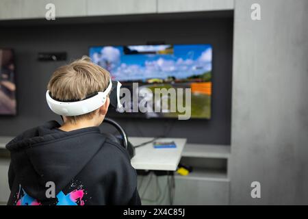 Osnabrück, Deutschland 29. Avril 2024 Im Bild : Ein Jugendlicher sitzt mit einer Virtual Reality brille, VR brille, vor einem Fernseher und spielt, zockt, ein Konsolenspiel auf einer Konsole. B ZEHN Niedersachsen *** Osnabrück, Allemagne 29 avril 2024 dans l'image Un jeune est assis devant une télévision avec des lunettes de réalité virtuelle, des lunettes VR, et joue, joue, un jeu de console sur une console B ZEHN Niedersachsen Copyright : xFotostandx/xGelhotx Banque D'Images