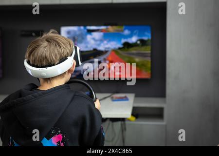 Osnabrück, Deutschland 29. Avril 2024 Im Bild : Ein Jugendlicher sitzt mit einer Virtual Reality brille, VR brille, vor einem Fernseher und spielt, zockt, ein Konsolenspiel auf einer Konsole. B ZEHN Niedersachsen *** Osnabrück, Allemagne 29 avril 2024 dans l'image Un jeune est assis devant une télévision avec des lunettes de réalité virtuelle, des lunettes VR, et joue, joue, un jeu de console sur une console B ZEHN Niedersachsen Copyright : xFotostandx/xGelhotx Banque D'Images