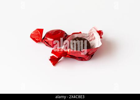 Deux bonbons de rue de qualité de saveur de fraise dans les nouveaux emballages en papier recyclable, l'un ouvert affichant le bonbon au chocolat. Banque D'Images