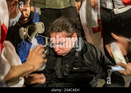 Tbilissi, Géorgie. 01 mai 2024. Un jeune homme est allongé sur le sol blessé par un jet de poivre de la police lors d'une manifestation devant le Parlement géorgien. Des milliers de personnes ont pris part à une manifestation contre la deuxième lecture d'un projet de loi qui a été voté pour faire avancer un projet de loi controversé sur les «agents étrangers» qui a déclenché des semaines de manifestations de masse dans la capitale, Tbilissi. (Photo de Nicholas Muller/SOPA images/SIPA USA) crédit : SIPA USA/Alamy Live News Banque D'Images