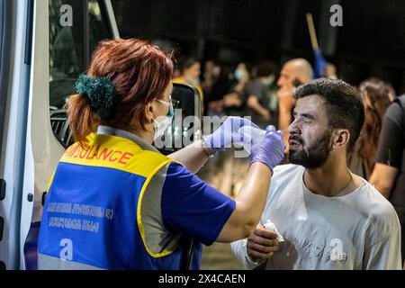 Tbilissi, Géorgie. 01 mai 2024. Un jeune homme se fait pulvériser de l'eau dans les yeux par un travailleur médical après s'être fait pulvériser du poivre par la police lors d'une manifestation devant le Parlement géorgien. Des milliers de personnes ont pris part à une manifestation contre la deuxième lecture d'un projet de loi qui a été voté pour faire avancer un projet de loi controversé sur les «agents étrangers» qui a déclenché des semaines de manifestations de masse dans la capitale, Tbilissi. (Photo de Nicholas Muller/SOPA images/SIPA USA) crédit : SIPA USA/Alamy Live News Banque D'Images