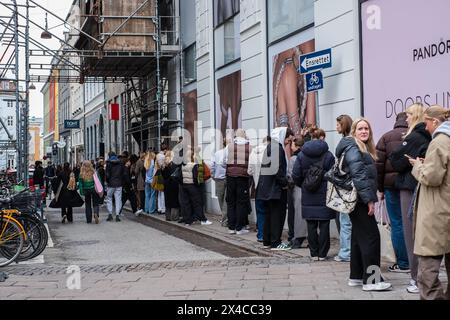 Copenhague, Danemark - 5 avril 2024 : des jeunes font la queue dans une rue pour le magasin pop up Globe Studios. Banque D'Images