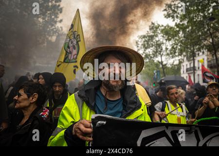 Paris, France. 01 mai 2024. Un manifestant est vu portant un gilet jaune pendant la manifestation de la fête du travail. Une journée pleine d'affrontements entre les groupes black-block, anarchistes et anticapitalistes, avec la police est devenue l'habitude lors de la célébration du 1er mai de la fête du travail à Paris, se plaignant du gouvernement du président Macron et de ses lois politiques et sociales. Crédit : SOPA images Limited/Alamy Live News Banque D'Images