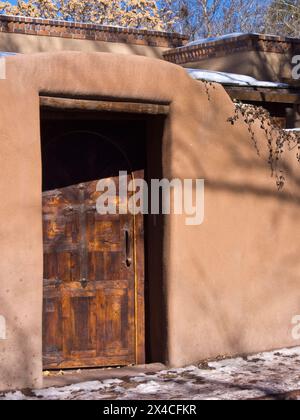 États-Unis, Nouveau-Mexique, Sante Fe. Vieille porte en bois sur une maison adobe. Banque D'Images