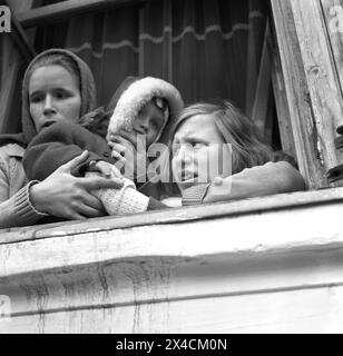 République socialiste de Roumanie dans les années 1970 Jeunes filles dans une ville de province assis sur un rebord de fenêtre, tenant un enfant en bas âge. Banque D'Images