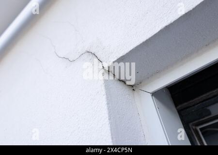 Gros plan d'une fissure dans le revêtement isolant de la façade près du linteau de la fenêtre Banque D'Images