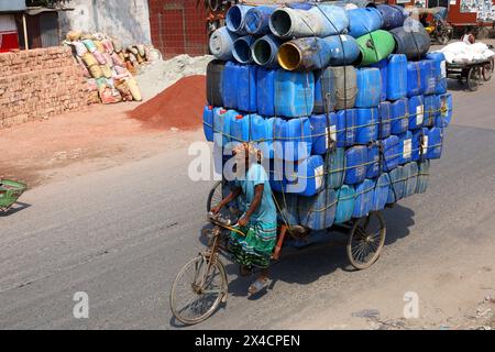 Dhaka, Dhaka, Bangladesh. 2 mai 2024. Un ouvrier transporte des fûts en plastique dans une camionnette à trois roues à Sadarghat à Dhaka. Généralement, ces fûts sont utilisés pour le transport de pétrole. (Crédit image : © Syed Mahabubul Kader/ZUMA Press Wire) USAGE ÉDITORIAL SEULEMENT! Non destiné à UN USAGE commercial ! Banque D'Images