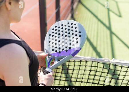 mains d'une joueuse de paddle tient des balles et la raquette à l'arrière-plan au début du match à l'extérieur Banque D'Images