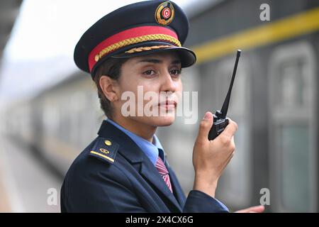 (240502) -- URUMQI, 2 mai 2024 (Xinhua) -- Airkir Duliki travaille dans une gare de Jinchang, dans la province du Gansu, au nord-ouest de la Chine, le 19 avril 2024. Airkir Duliki, le chef de train tadjik âgé de 27 ans, est né et a grandi au milieu des montagnes enneigées et des prairies dans un village du comté autonome tadjik de Taxkorgan sur le plateau du Pamir, où les chemins de fer n'étaient pas courants pour les résidents dans le passé. La première expérience d'Airkir avec le voyage en train s'est produite quand elle s'est rendue à Urumqi pour l'université au Xinjiang. Accompagnée de son père, elle a parcouru plus de 300 kilomètres de ter montagneux Banque D'Images