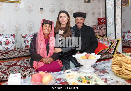 (240502) -- URUMQI, 2 mai 2024 (Xinhua) -- Airkir Duliki (C) et ses parents posent pour une photo à la maison au comté autonome tadjik de Taxkorgan dans la région autonome ouïgur du Xinjiang, au nord-ouest de la Chine, 23 mars 2024. Airkir Duliki, le chef de train tadjik âgé de 27 ans, est né et a grandi au milieu des montagnes enneigées et des prairies dans un village du comté autonome tadjik de Taxkorgan sur le plateau du Pamir, où les chemins de fer n'étaient pas courants pour les résidents dans le passé. La première expérience d'Airkir avec le voyage en train s'est produite quand elle s'est rendue à Urumqi pour l'université au Xinjiang. Accompagné de h. Banque D'Images