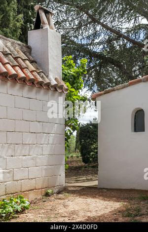 Certains bâtiments attachés à une maison de campagne avec une construction de ferme de style andalou entourée d'arbres feuillus Banque D'Images