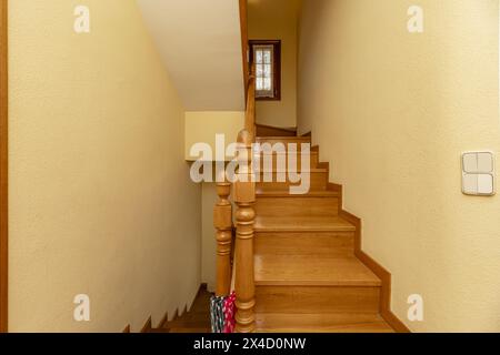 Escaliers intérieurs d'une maison unifamiliale avec balustrades en bois de chêne avec mains courantes en bois et marches du même matériau Banque D'Images