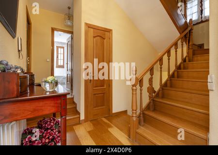 Escalier intérieur d'une maison unifamiliale avec un palier avec un buffet en bois avec balustrades en bois de chêne et un plancher du même matériau Banque D'Images