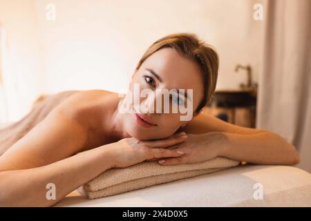 Belle femme se détend pendant le massage du dos. Femme heureuse appréciant le massage du dos pendant le week-end de temps sur le centre de spa Banque D'Images