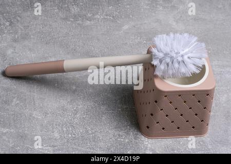 Brosse de nettoyage des toilettes sur un fond gris, gros plan Banque D'Images