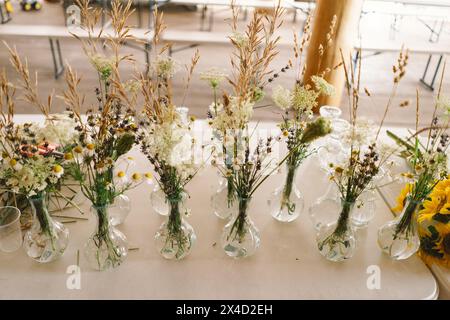 Élégantes pièces maîtresses de fleurs sauvages ornant une table de fête lors d'un événement intérieur Banque D'Images
