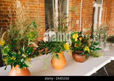 Élégantes pièces maîtresses de fleurs sauvages ornant une table de fête lors d'un événement intérieur Banque D'Images