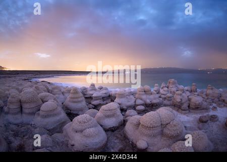 Photo d'un champignon salé dans la mer morte avec un lever de soleil dans le fond et des nuages dans le ciel Banque D'Images