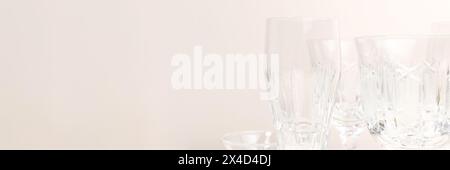 Verres en cristal devant un fond beige. Bannière avec espace de copie. Banque D'Images