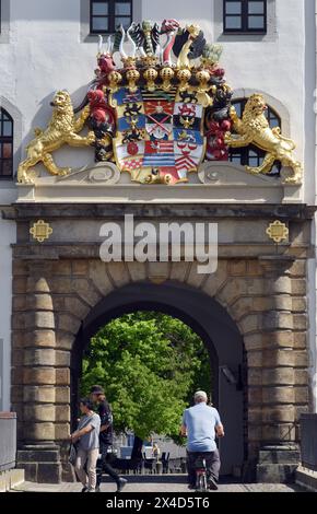 PRODUCTION - 29 avril 2024, Saxe, Torgau : les visiteurs passent devant l'entrée du château de Hartenfels avec la chapelle du château, également connue sous le nom d'église du château. Dans la chapelle, construite sur les conseils du réformateur Martin Luther (1443-1546) et consacrée par lui en 1544, les premiers hymnes choraux sont chantés par le compositeur et chanteur Johann Walter (1496-1570), qui vit à Torgau. Cette année marque le 500e anniversaire du hymne allemand, dans lequel les chœurs polyphoniques des choraux protestants les plus importants ont été publiés pour la première fois à Wittenberg. Johann Walter, un ami de la réf Banque D'Images