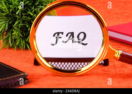 FAQ ( Foire aux questions ) texte à travers une loupe sur une carte de visite blanche Banque D'Images