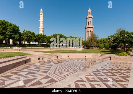 Une cour, des jardins et des minarets à la Grande Mosquée Sultan Qaboos, Mascate, Oman. Banque D'Images
