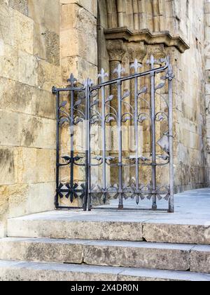 Porte en fer à l'entrée latérale de la vieille cathédrale de Coimbra. Banque D'Images