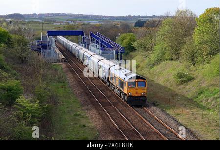 La locomotive GBRF no 66750 passe devant la gare de Horden, sur la côte nord-est, avec une autre charge de bio-masse importée pour la centrale de Drax. Banque D'Images