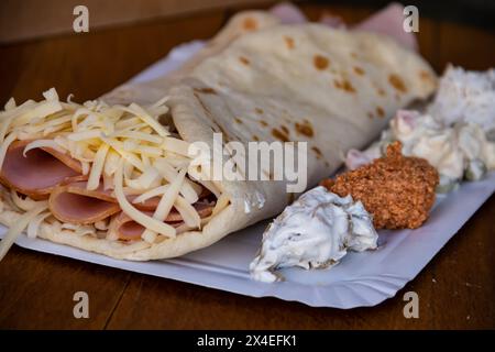 Une crêpe dorée salée fourrée de jambon et de fromage fondu offre une délicieuse combinaison de saveurs. Banque D'Images