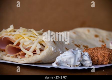 Une crêpe dorée salée fourrée de jambon et de fromage fondu offre une délicieuse combinaison de saveurs. Banque D'Images