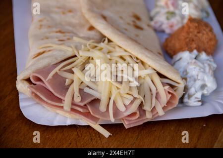 Une crêpe dorée salée fourrée de jambon et de fromage fondu offre une délicieuse combinaison de saveurs. Banque D'Images