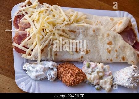 Une crêpe dorée salée fourrée de jambon et de fromage fondu offre une délicieuse combinaison de saveurs. Banque D'Images