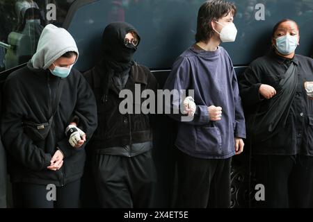 Londres, Royaume-Uni. 02 mai 2024. Des manifestants masqués forment une chaîne humaine autour d'un autocar qui tente d'emmener des migrants à la barge de Bibby Stockholm pendant la manifestation. Les manifestants et la police se sont affrontés lors d'une manifestation dans le sud de Londres au sujet du transfert prévu de demandeurs d'asile vers la barge Bibby Stockholm dans le Dorset. (Photo de Thabo Jaiyesimi/SOPA images/SIPA USA) crédit : SIPA USA/Alamy Live News Banque D'Images