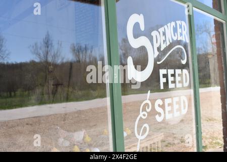 Spencer, Missouri, États-Unis - 4-13-24. Un regard partiel sur l'ancien magasin d'aliments et de semences, avec des reflets de la campagne environnante. Banque D'Images