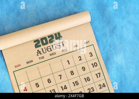 Août 2024 calendrier plat repose sur fond bleu avec espace de copie. Banque D'Images