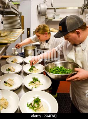 États-Unis, État de Washington, Woodinville. Le chef Breanna Beike et son équipe préparent des assiettes lors d'un dîner de vignerons au Heritage Restaurant and Bar. (Utilisation éditoriale sur Banque D'Images