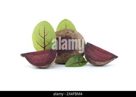 Des tranches de betterave, révélant leurs intérieurs violets vibrants, sont soigneusement disposées à côté de légumes de betterave entiers, avec leur vert frais Banque D'Images