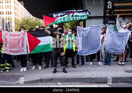 New York, États-Unis. 02 mai 2024. Les manifestants pro-palestiniens brandissent des keffiyehs et des drapeaux palestiniens pour bloquer la vue de la presse. Une femme au masque se tient devant agitant un drapeau qui dit que les tensions de la « liberté pour la Palestine » augmentent alors que les manifestants pro-palestiniens à la New School de New York rencontrent des contre-manifestants pro-israéliens. L'organisation New School Students for Justice in Palestine a installé un campement à l'intérieur du bâtiment de l'école il y a 11 jours, exigeant que l'école divulgue et cède tout lien financier avec Israël. Crédit : SOPA images Limited/Alamy Live News Banque D'Images