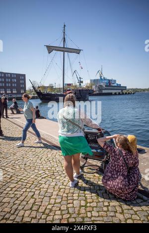 IM Wismarer Hafen beobachten Urlauber das Einlaufen der Poeler Kogge in den Hafen der Hansestadt. IM Wismarer Hafen liegt ein vom Wrackfund Poel 11 inspirierter Nachbau einer Hansekogge. Dieser Nachbau erfolgte in bewusster Anlehnung an Schiffsbaumethoden des 14. Jahrhunderts. DAS Schiff wurde AM 29. Mai 2004 per Stapelhub ins Wasser gesetzt und auf den Namen Wissemara getauft. Nach dem Setzen des mastes, dem Bau des Achterkastells, der montage eines Hilfsmotors sowie weiterer Arbeiten erfolgte AM 9. Août 2006 die Jungfernfahrt der Kogge zur Hanse Sail nach Rostock. Der Nachbau dient während Banque D'Images