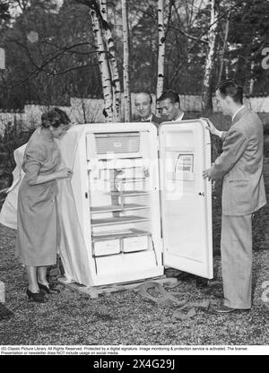 Congélateur dans les années 1950 Une toute nouvelle unité de congélation présentée, enveloppée dans du papier cadeau et présentée à la presse. Fabriqué par le fabricant américain d'appareils ménagers grand public Frigidaire. Les aliments surgelés seraient le début d'une révolution dans les habitudes domestiques et le stockage des aliments. Beaucoup étaient sceptiques, et en particulier les fabricants d'aliments en conserve considéraient les aliments congelés comme une tendance passagère. 1955 Banque D'Images