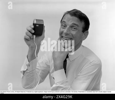 Dans les années 1960 Un homme visiblement heureux en doigtant sa joue et ses mentons ayant utilisé le rasage électrique du fabricant Braun. 1968 Kristoffersson ref 387A-9 *** local légende *** Banque D'Images