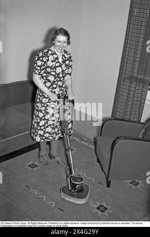 Journée de nettoyage dans les années 1940 Une femme au foyer fait la démonstration du dernier appareil de nettoyage pour rafraîchir les tapis. 1940. Kristoffersson ref 54-11 Banque D'Images