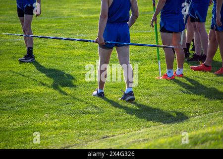 Jeunes athlètes d'athlétisme en uniforme avec des javelots sur le terrain en herbe Banque D'Images