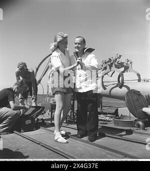 Åke Söderblom, 1910-1965, acteur suédois ici pendant le tournage d'un long métrage sur un navire de guerre suédois. Il est vêtu d'un uniforme de marin et on le voit danser avec une jeune femme blonde sur le pont du navire pendant une pause dans le tournage. Kristofferson 1946. réf. O82-1 Banque D'Images