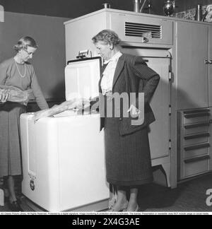 Boîte de congélation dans les années 1950 La baronne Märtha Roshall avec la baronne Madeleine Leijonhufvud dans un congélateur du fabricant américain Philco, où ils conservent des aliments surgelés. Les aliments surgelés seraient le début d'une révolution dans les habitudes domestiques et le stockage des aliments. Beaucoup étaient sceptiques, et en particulier les fabricants d'aliments en conserve considéraient les aliments congelés comme une tendance passagère. 1950 Banque D'Images