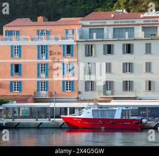 Bonifacio, Corse-du-Sud, Corse, France. Vue depuis le quai de l'autre côté du port jusqu'à la façade rose pastel du Hôtel du Roy d'Aragon, au lever du soleil. Banque D'Images